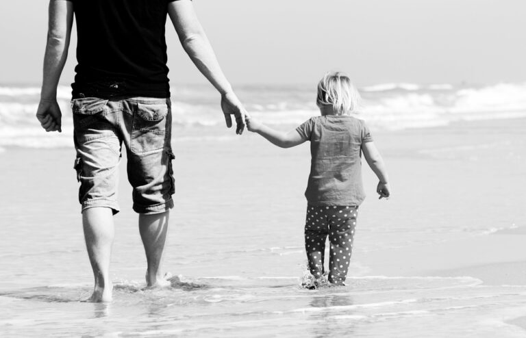 Dad and daughter walking on beach