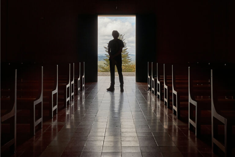 Man standing at end of church hallway