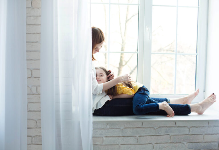 Mother sitting with child in window