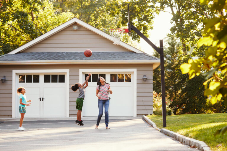 Family playing basketball outside home