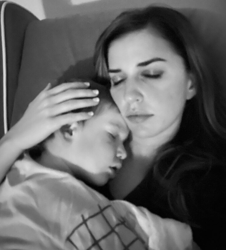Mom holding sleeping boy, black-and-white photo