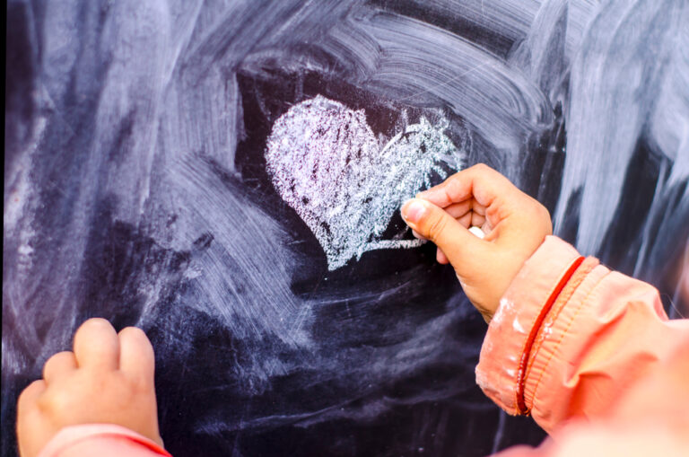 Child drawing chalk heart