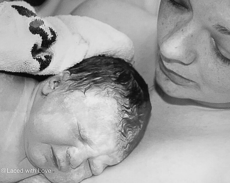 Mother holding newborn after delivery, black-and-white photo