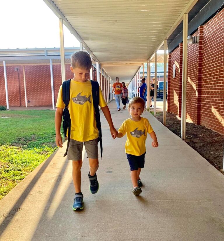 Boys walking from school building holding hands