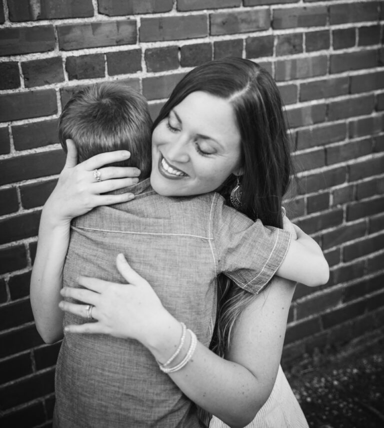 Mother hugging her young son, black-and-white photo