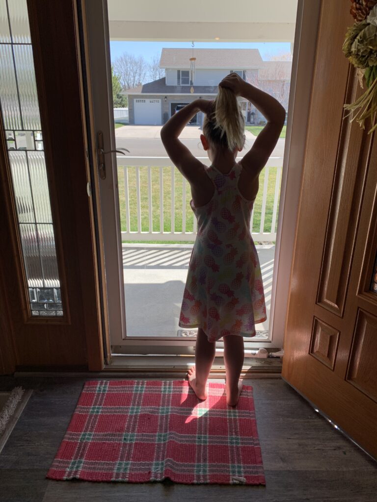 Little girl looking out front door, color photo