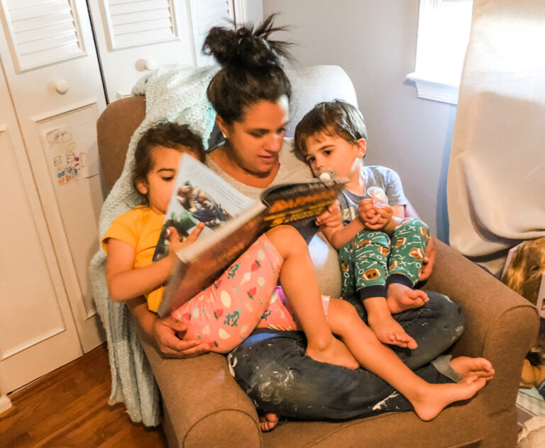 Mother reading with kids on her lap, color photo