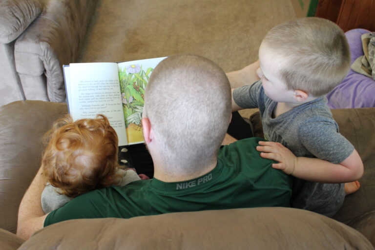 Daddy reading to his children, color photo