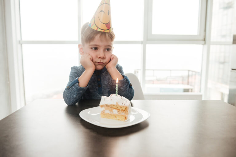 Sad child with birthday cake