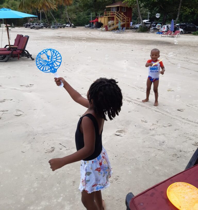Children playing with bubbles on the beach, color photo