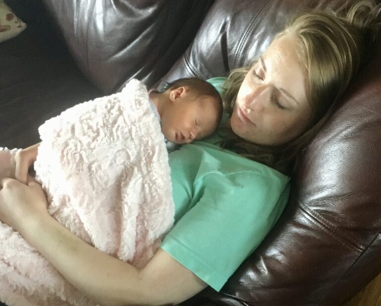 Mother with sleeping newborn on her chest, color photo