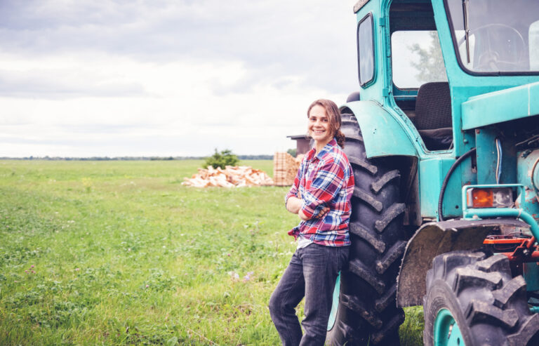 Woman standing by tractor on farm