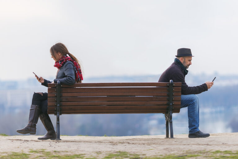 Man and woman on bench with distance