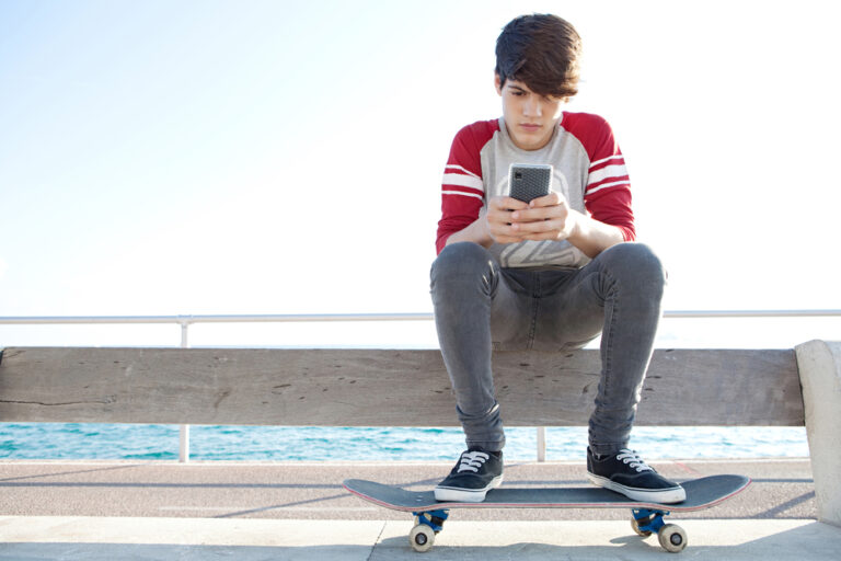 Teenage boy sitting with phone