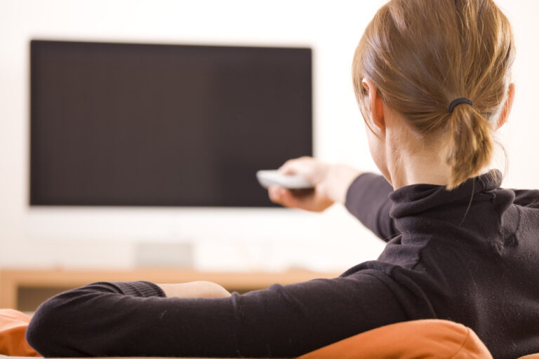 Woman with remote pointed at tv