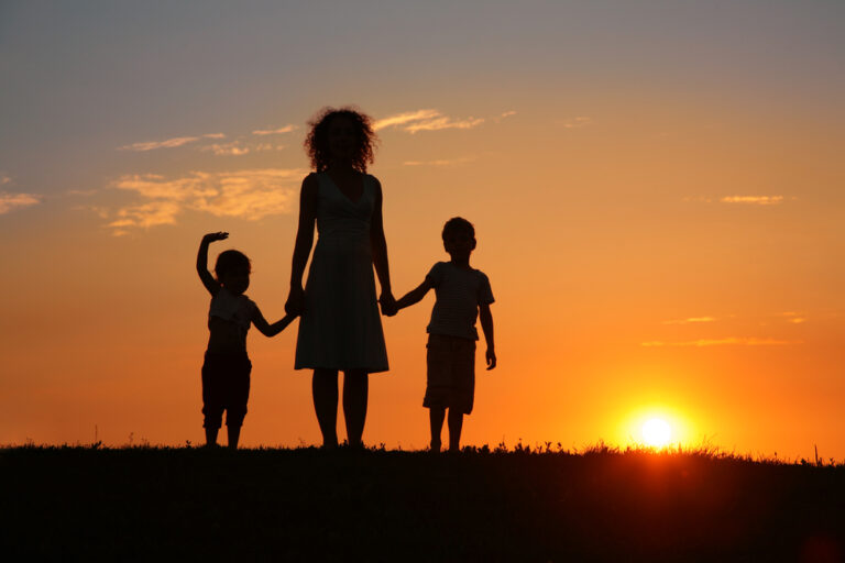 Mother holding kids hands silhouette