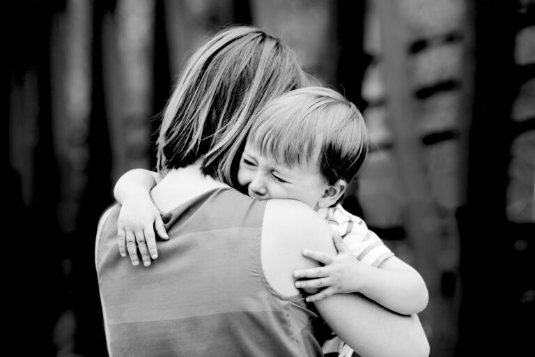 Mom hugging crying boy