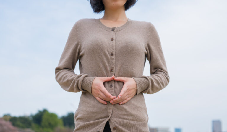 Woman making heart over stomach