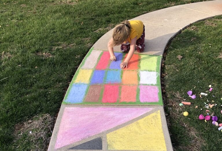 Child drawing with sidewalk chalk