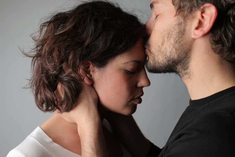 Man kissing woman's forehead