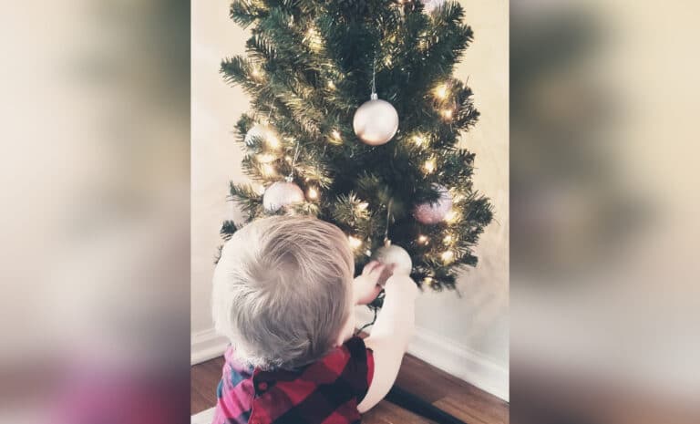Child by Christmas tree