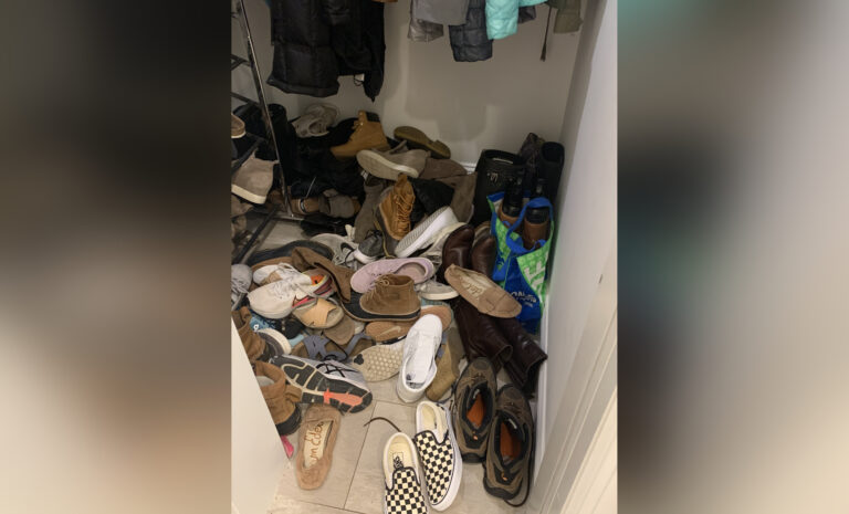 Pile of shoes in entry way, color photo