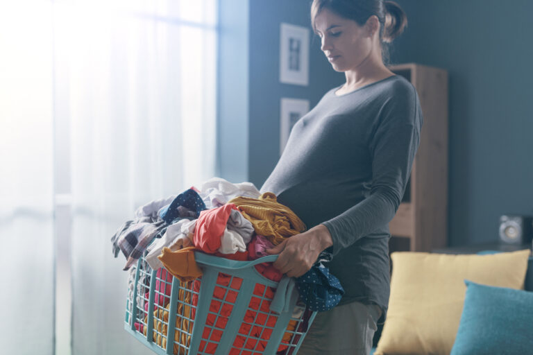 Woman carrying laundry basket at home