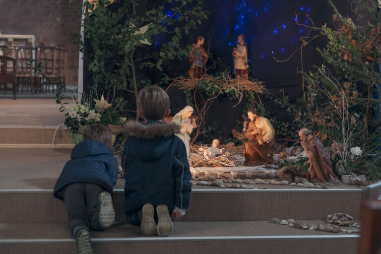 Children kneeling at nativity scene