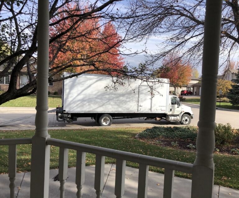 Moving truck outside home, color photo