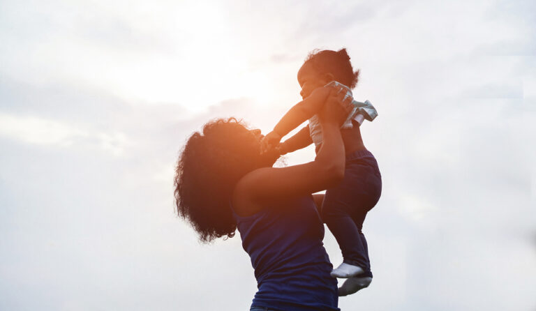 Woman holding baby in the air