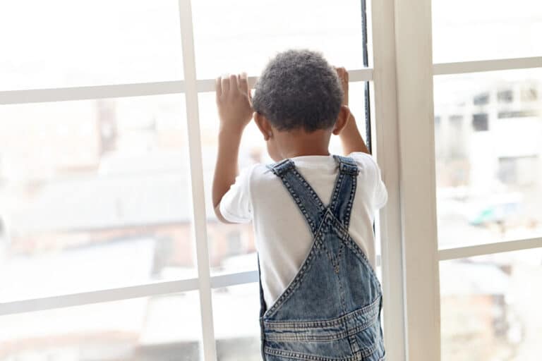 Little boy looking out window