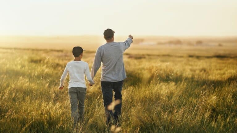 Father and son in field walking