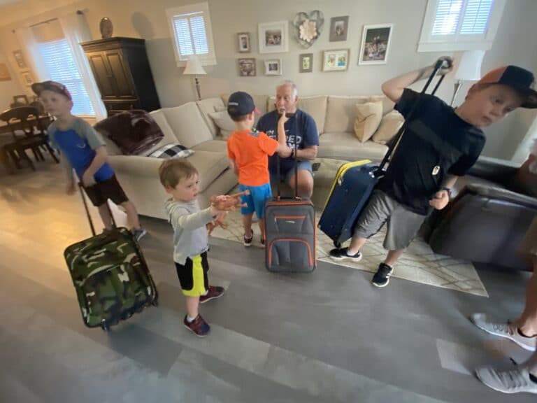 Kids in living room with suitcases, color photo