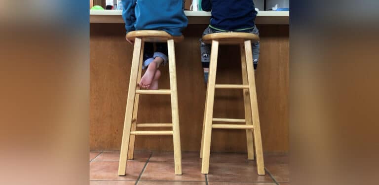 Little kids sitting on barstools, color photo