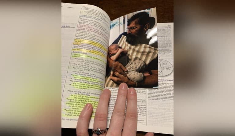 Bible with picture stuck inside of man holding baby, color photo