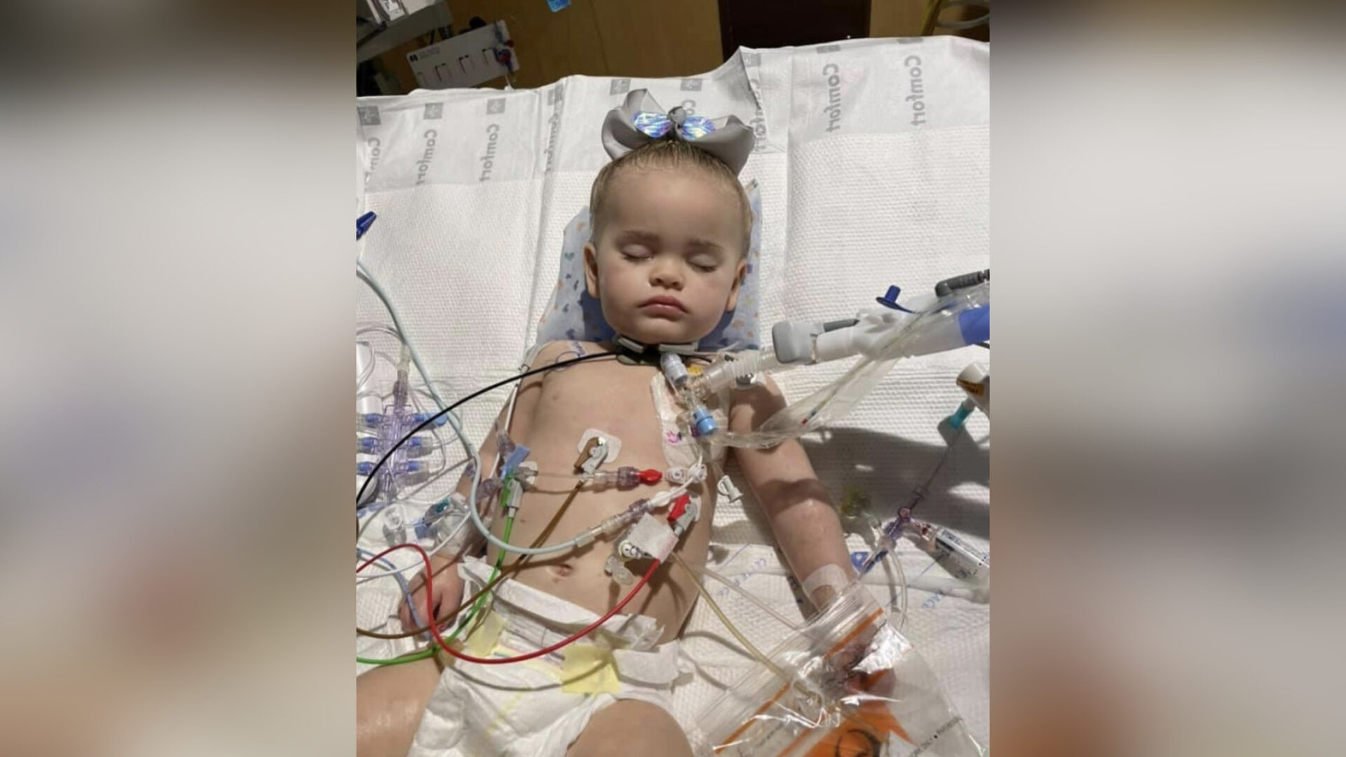 Child attached to tubes in hospital bed