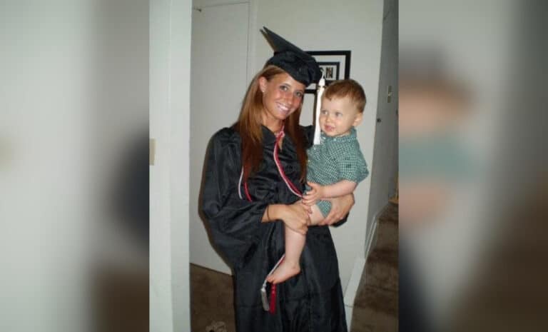Woman in cap and gown holding toddler