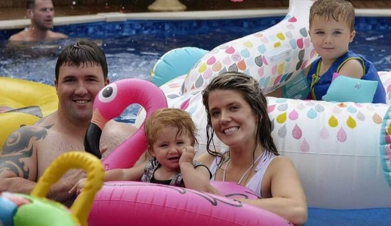 Husband and wife with children in swimming pool, color photo