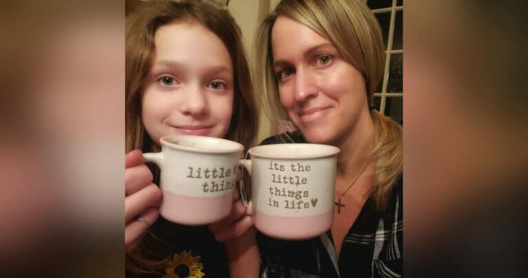 Woman and daughter holding coffee cups, color photo