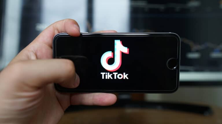 Hand holding cell phone with TikTok logo