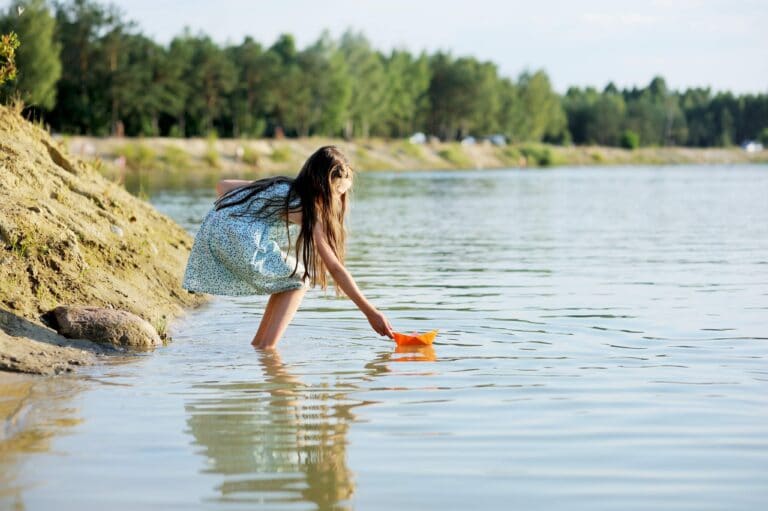 Tween girl standing in the water of a river, color photo