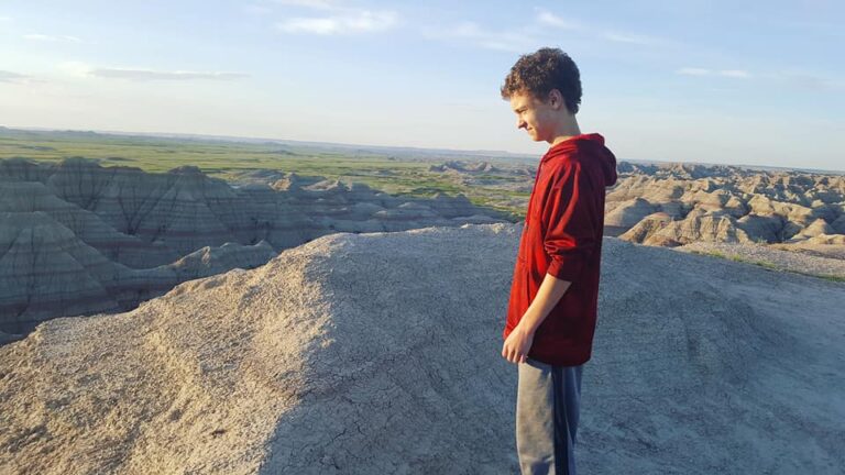 Boy standing on nature overlook, color photo