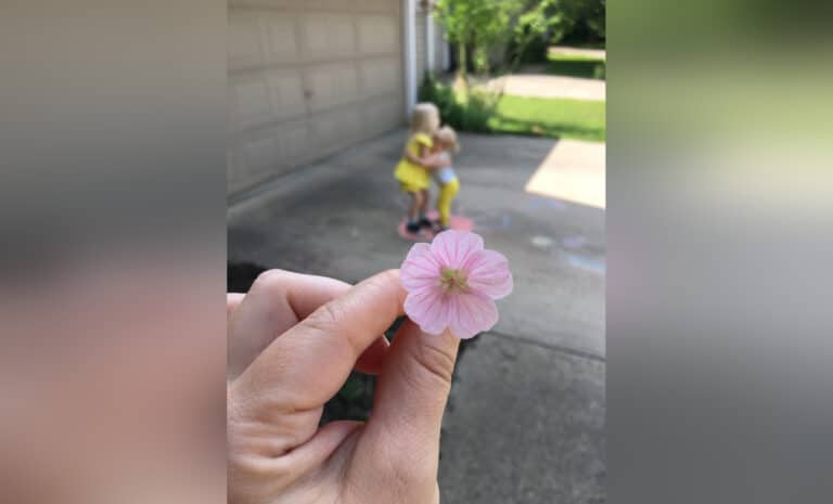 Mother holding small garden flower, color photo