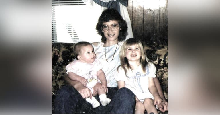 Mother and two daughters on floral couch, old color photo