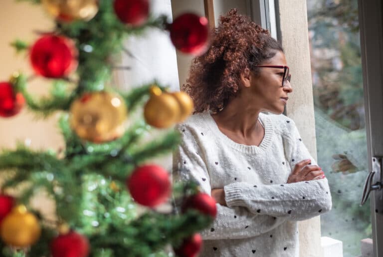 Woman by window and Christmas tree