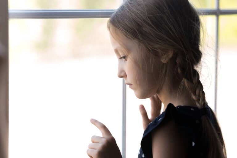 Little girl standing by window