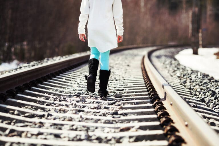 Woman walking down railroad