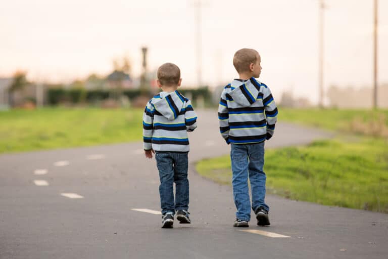 Two little boys walking down road