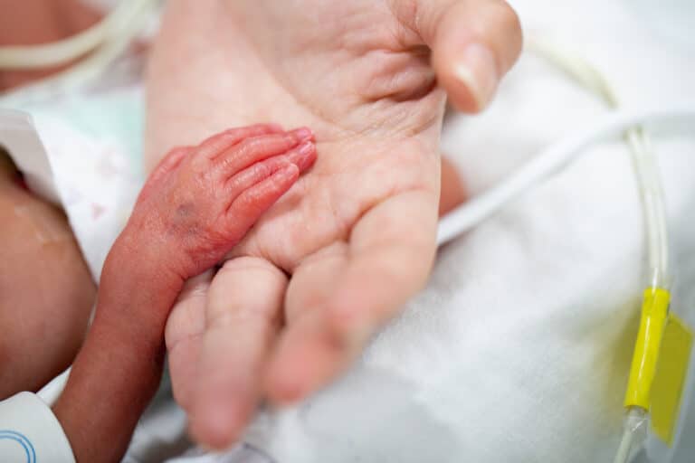 Premature baby hand in mother's hand