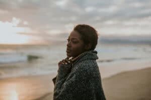 Woman by ocean at sunset